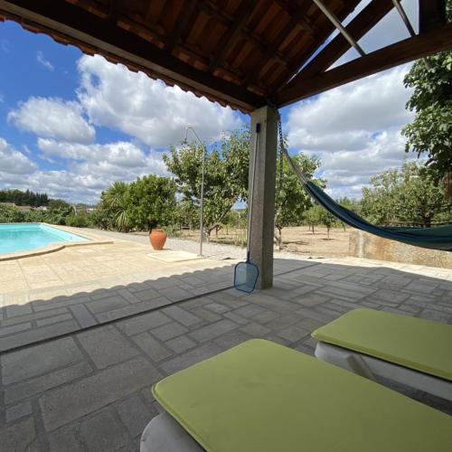 a patio with a hammock and a swimming pool at Giravillage in Girabolhos