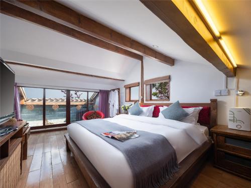 a bedroom with a large bed and a large window at Lijiang Merry Inn in Lijiang