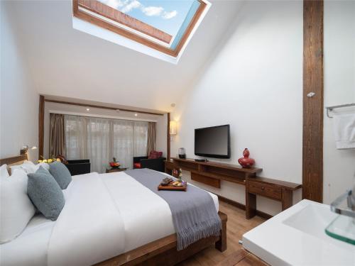 a bedroom with a large bed and a television at Lijiang Merry Inn in Lijiang