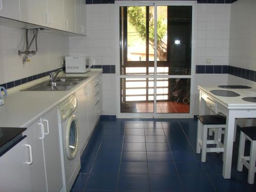 Il comprend une cuisine équipée d'un évier et d'un lave-linge. dans l'établissement Apartamento Capela, à Funchal
