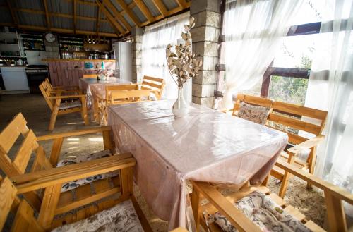 een eetkamer met een tafel en stoelen met een vaas erop bij Ретритный центр "Дом Души" in Nieuw Athos