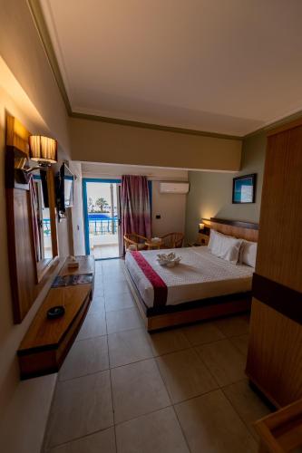 a bedroom with a bed and a table and a window at Noras Beach Hotel in Port Said