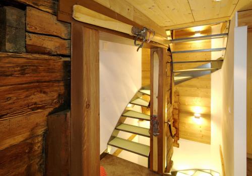 a spiral staircase in a cabin with wooden walls at Ferienapartement Hinterdorf in Zermatt