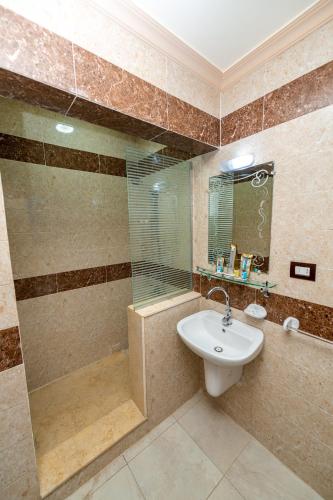 a bathroom with a glass shower and a sink at Noras Beach Hotel in Port Said