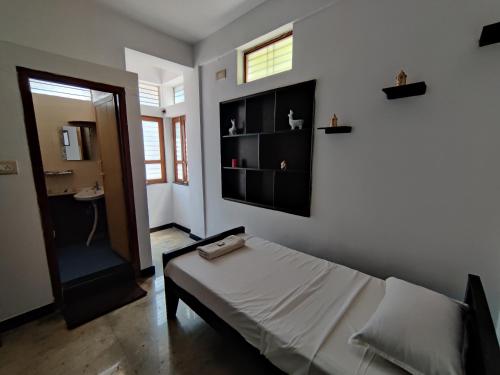 1 dormitorio con cama, ventana y puerta en Yoga House, en Vānivilāsa Puram