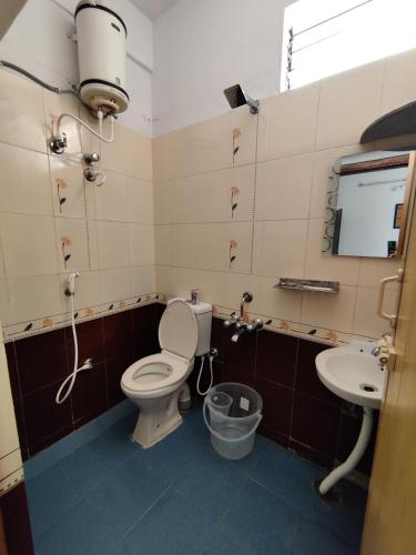 a bathroom with a toilet and a sink at Yoga House in Vānivilāsa Puram