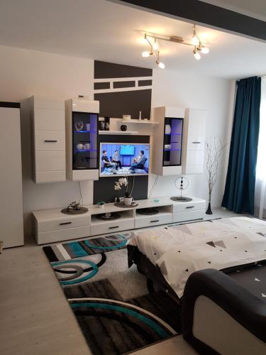 sala de estar con TV y cama en Apartament Sofy2, en Băile Herculane