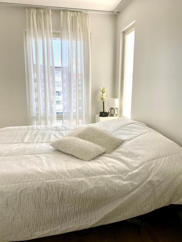a bedroom with a white bed with a window at The River 31, Baritoni in Pori