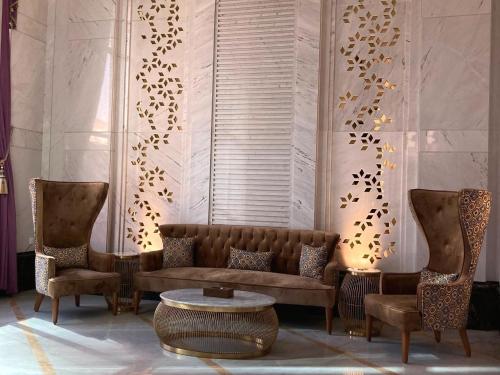 a living room with a couch and two chairs and a table at Midan Hotel & Suites Al Aziziya in Makkah