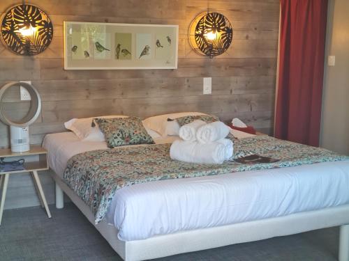 a bedroom with a bed with towels on it at Hôtel Le Sens in Vaux-sur-Mer
