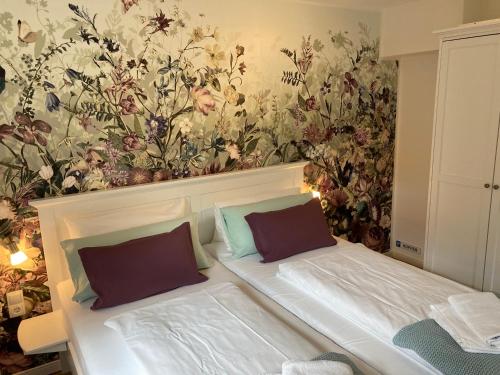 1 dormitorio con 1 cama y papel pintado con motivos florales en Appartement 2 Garten en Bergen auf Rügen