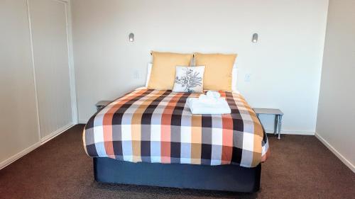 a bedroom with a bed with a colorful blanket at Lake Vista in Lake Tekapo