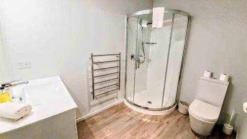 a white bathroom with a shower and a toilet at Lake Vista in Lake Tekapo