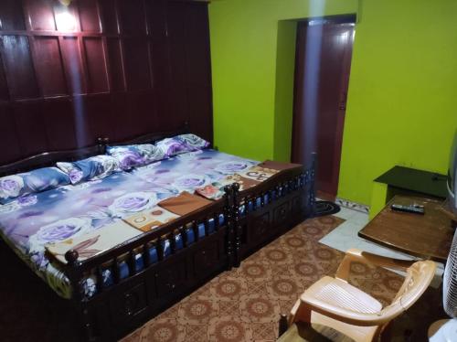 a bedroom with a bed and a table and a chair at RAOJI Home Stay in Vālpārai