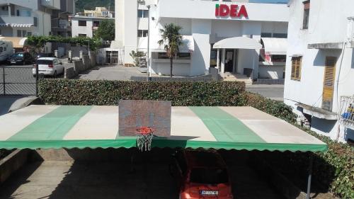 a basketball court with a green awning and a basketball hoop at Apartments Stevo Nikočević in Bar