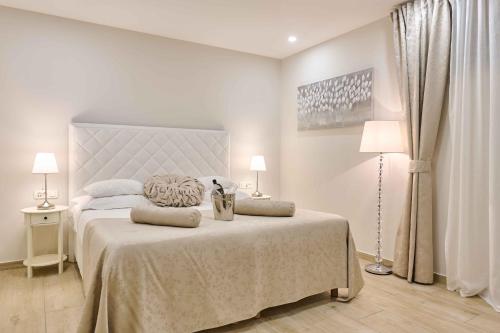 a white bedroom with a large bed with two lamps at Best location Rooms in Split