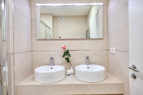 a bathroom with two sinks and a mirror at Best location Rooms in Split