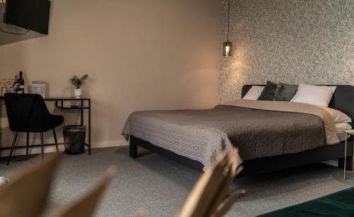 a bedroom with a bed and a desk and a tub at Dobosi Birtokközpont in Szentantalfa