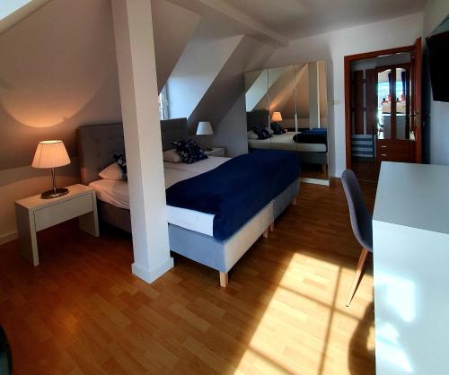 a bedroom with a bed with a blue comforter at Przystań Nad Zatoką - Gospodarstwo Agroturystyczne in Lubieszewo