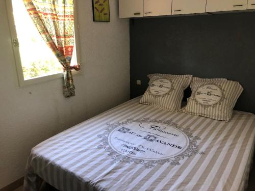 Una cama con un cartel encima. en Chalet La Dragonniere, en Vias