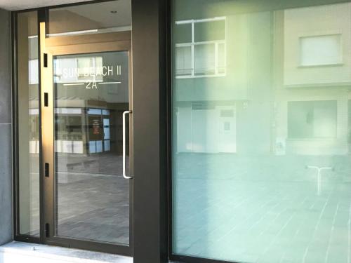 a glass door of a building with a view of a street at Studio zee in Nieuwpoort