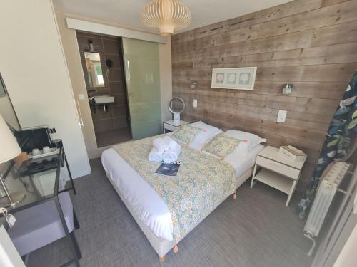 a bedroom with a bed and a desk and a television at Hôtel Le Sens in Vaux-sur-Mer