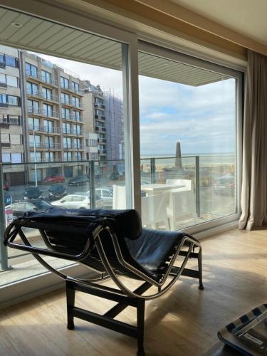 a chair in a room with a large window at Blankeduyn Koksijde in Koksijde