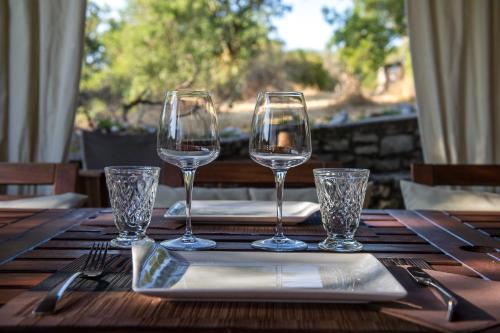 a table with four wine glasses and a napkin at Aux Lodges du Mas de Nadal in Sauliac-sur-Célé