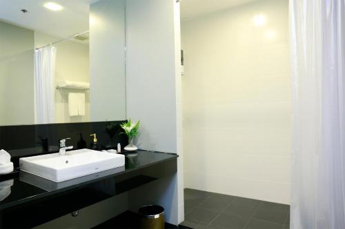 a bathroom with a white sink and a mirror at Sleep Box by Miracle -Booked on Hourly Basis in Bangkok