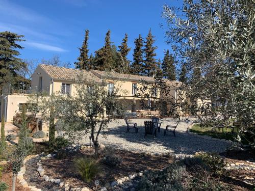 a house with a yard with chairs and trees at Mon Chemin Privé in Mirabel-aux-Baronnies
