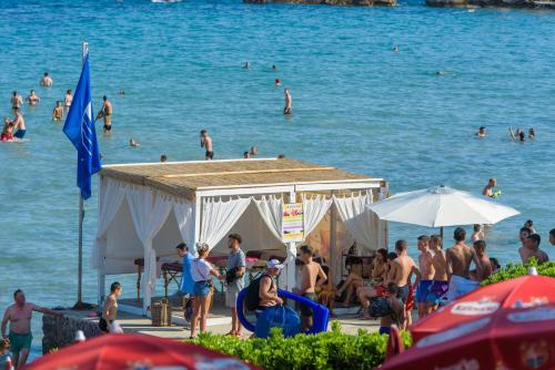 a group of people on a beach with people in the water at Best location Rooms in Split