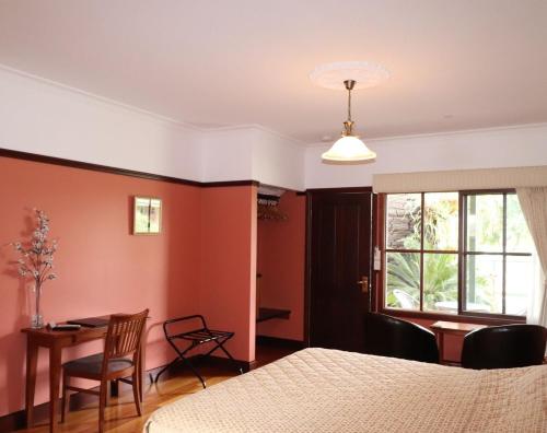 にあるSnowy river homesteadのベッドルーム1室(ベッド1台、テーブル、窓付)