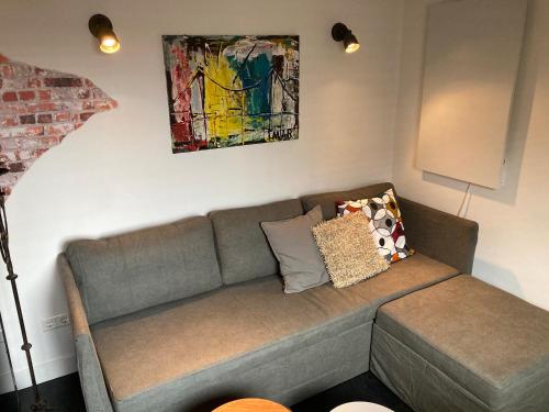 a couch in a living room with a painting on the wall at Holiday Tiny House in Spakenburg Bed & Bike in Spakenburg