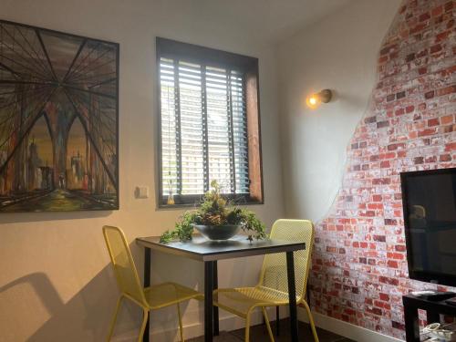 a dining room with a table and yellow chairs at Design BB Bed&Bike holiday cottage Tiny Home in Spakenburg in Spakenburg