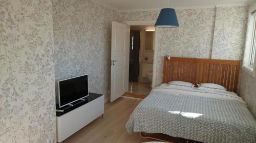 sypialnia z łóżkiem i telewizorem z płaskim ekranem w obiekcie Simones Hotel w mieście Vadstena