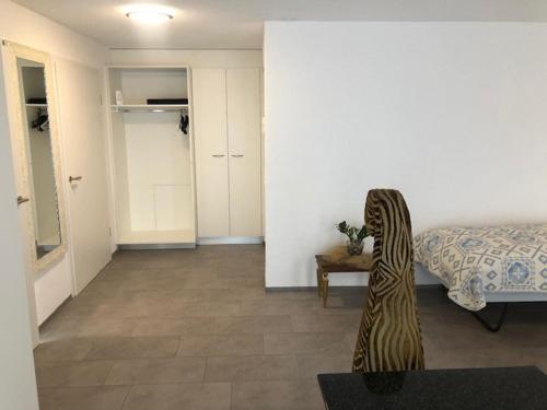 a bedroom with a bed and a table with a statue at Hotel Hippel Krone in Kerzers
