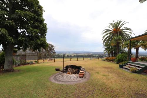 a fire pit in the middle of a grass field at Snowy river homestead in Newmerella