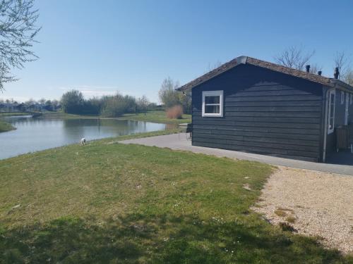 a small building next to a body of water at Resort Land & Zee in Scharendijke