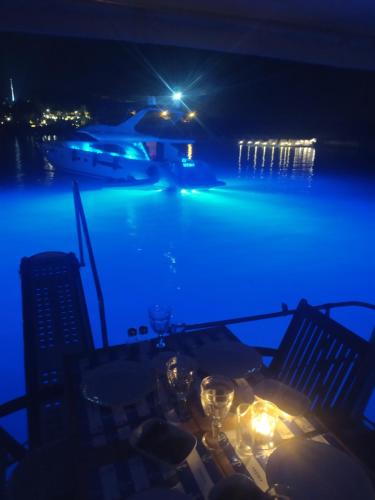 a pool at night with a table and chairs at cesme yat isletmeciligi in Çeşme