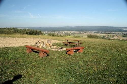 two picnic tables and benches on top of a field at Noclegi u Banysia w sercu Gór Świętokrzyskich in Krajno Pierwsze