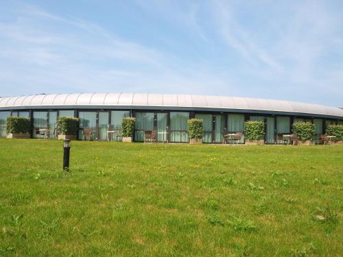a building with a grass field in front of it at Resort Land & Zee in Scharendijke
