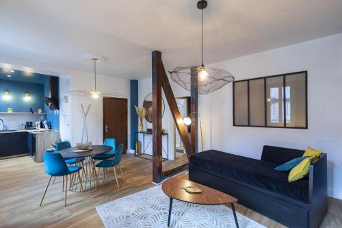 a living room with a blue couch and a table at PARENTHESE - Le Vignemale in Lourdes