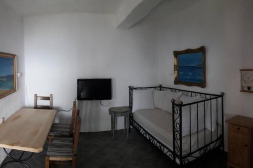 a bedroom with a bed and a table and a tv at Ferienwohnung Castello Sebastian in Argalasti