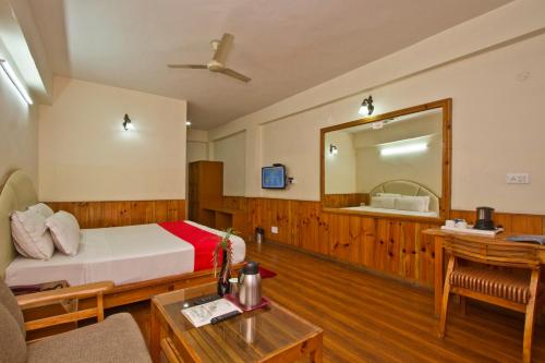 a hotel room with a bed and a mirror at Sarthak Resorts-Reside in Nature with Best View, 9 kms from Mall Road Manali in Manāli