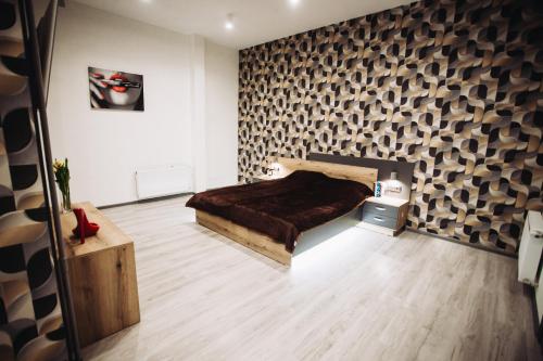 Schlafzimmer mit einem Bett und Holzboden in der Unterkunft LOFT de luxe apartments in Winnyzja