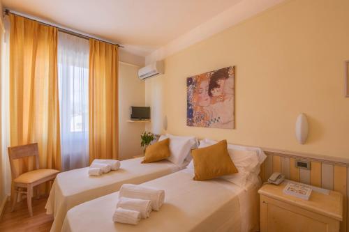 pokój hotelowy z dwoma łóżkami i oknem w obiekcie Hotel Massimo w mieście Marina di Cecina