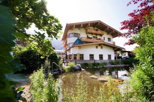 a house with a pond in front of it at Landhaus Alpenherz in Aschau