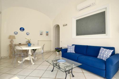 a living room with a blue couch and a table at L'Ancora Amalfi Dreams in Minori