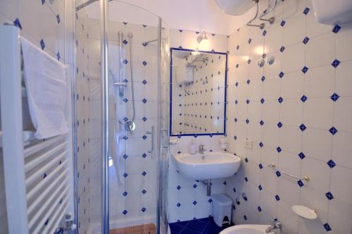 een badkamer met een wastafel, een toilet en een spiegel bij L'Ancora Amalfi Dreams in Minori