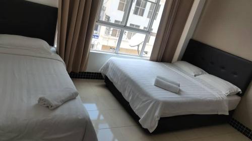 um quarto com uma cama branca e uma janela em LSN Hotel (KL) Sdn Bhd em Kuala Lumpur